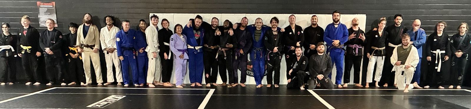 Adults and teens from every belt lined up along the academy wall