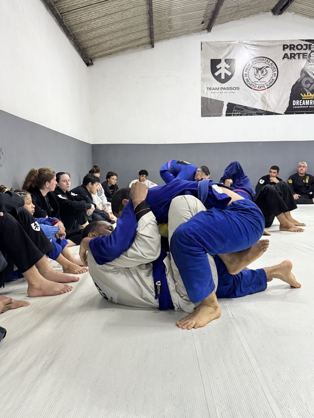Training partners rolling while the class looks on in Brazil